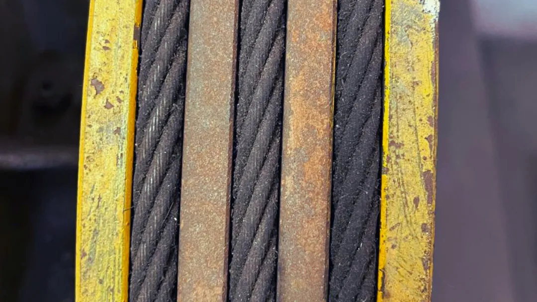 Detalle de los cables de tracción de un ascensor bajo inspección.